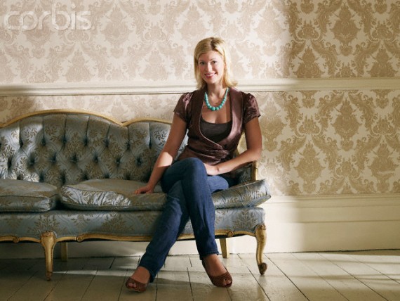 Young Woman Sitting on Ornate Sofa